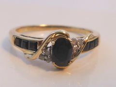 Sapphire & 9ct Gold Cluster Ring    Set with oval cut dark sapphire to centre