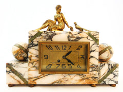 Mantel Clock in Marble with Figurines in brass alloy (messing/laiton) on top of a Lady feeding a Pheasant. Eight-day clock movement with chime. France 1920s.