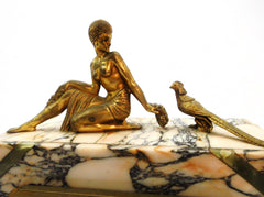 Mantel Clock in Marble with Figurines in brass alloy (messing/laiton) on top of a Lady feeding a Pheasant. Eight-day clock movement with chime. France 1920s.